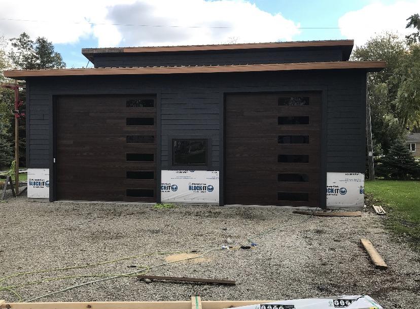 Modern wood tone plank garage doors with windows 